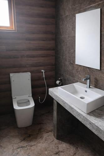 a bathroom with a white toilet and a sink at Sky Glow Residence in Pepiliyana