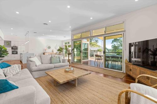 a living room with a couch and a table at Aerial Blue Mollymook in Mollymook