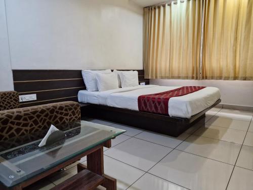 a hotel room with a bed and a couch at Hotel Radiant Kolhapur in Kolhapur