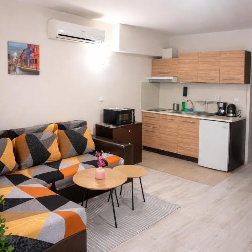 a living room with a couch and a table and a kitchen at The White Houses 7 in Nesebar