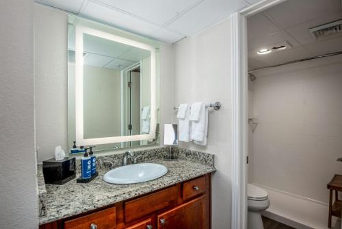 a bathroom with a sink and a mirror and a toilet at Club Wyndham Durango in Durango