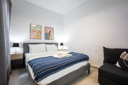 una camera da letto con un letto con una coperta a righe blu e bianche di Modern Studio l King Bed & Work Corner ad Atene