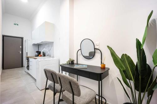 una piccola cucina con tavolo e sedie neri di Modern Studio l King Bed & Work Corner ad Atene