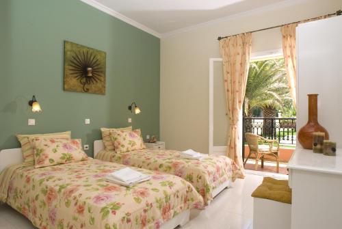 
a bedroom with two beds and two lamps at Dimitris Apartments in Sidari
