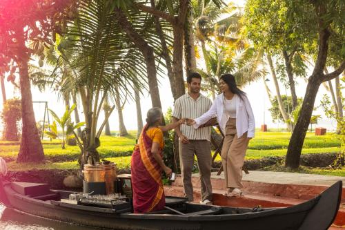 a man shaking the hand of a woman on a boat at Coconut Lagoon Kumarakom - A CGH Earth Experience in Kumarakom