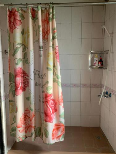 a shower curtain with flowers on it in a bathroom at Scarecrow Homestay in Jincheng