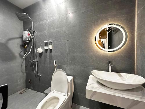 a bathroom with a sink and a toilet and a mirror at Mai Phương Motel in Pleiku
