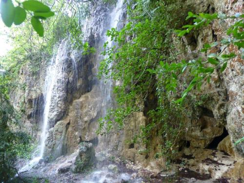 a waterfall on the side of a rocky cliff at La Fusteria del Casat in Sarroca de Bellera
