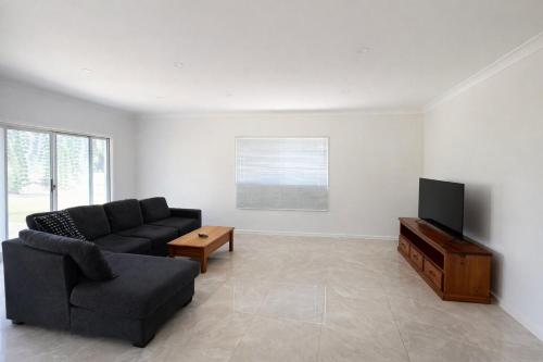 a living room with a couch and a flat screen tv at Entire House walk to South Bank mater in Brisbane