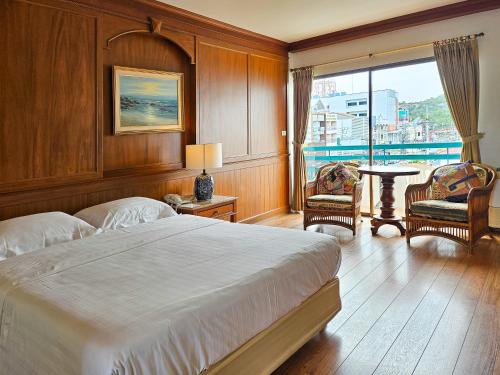 a bedroom with a bed and a large window at Sirin Hotel Hua Hin in Hua Hin