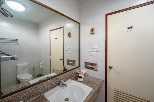 a bathroom with a sink and a toilet and a mirror at Sirin Hotel Hua Hin in Hua Hin