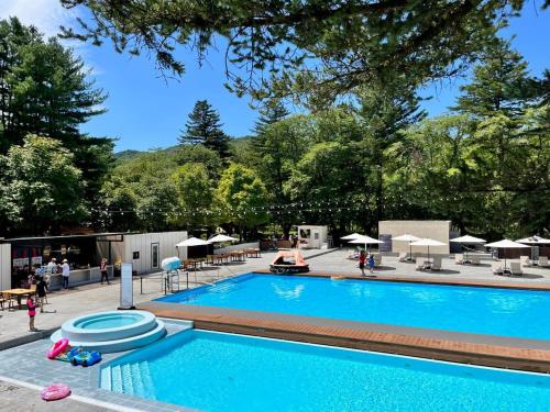 a swimming pool with umbrellas and umbrellas at Nami Island Hotel Jeonggwanru in Chuncheon