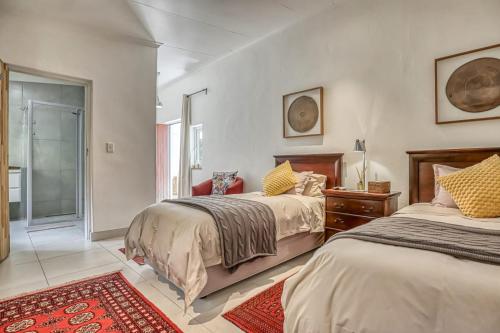 a bedroom with two beds and a red rug at French Bistro Studio in Johannesburg