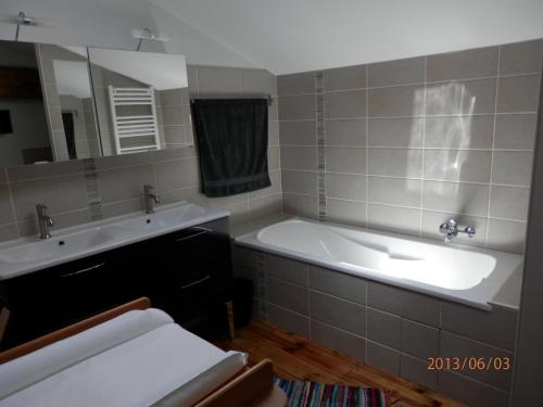 La salle de bains est pourvue d'une baignoire, d'un lavabo et d'un miroir. dans l'établissement L'âne Vert, à Saint-Méard-de-Gurçon