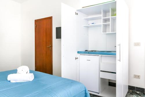 a small room with a blue bed and a kitchen at Inlaguna in Venice