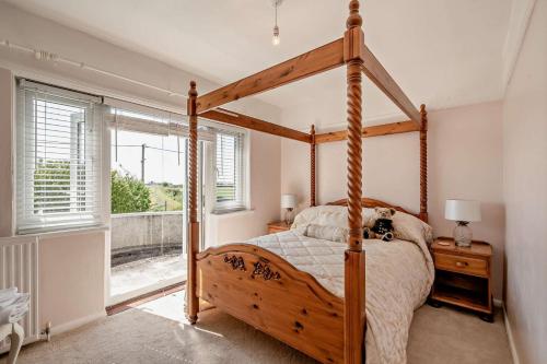 a bedroom with a wooden canopy bed and a window at 4 Bed in Nottage oc-a32048 in Nottage