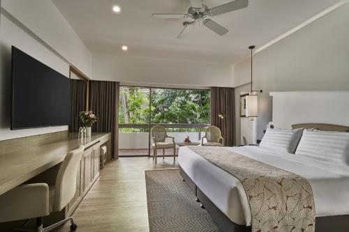 a bedroom with a large bed and a large window at Goodwood Park Hotel in Singapore