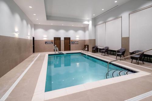 a swimming pool in a building with chairs and tables at La Quinta Inn & Suites by Wyndham Nashville Downtown Stadium in Nashville