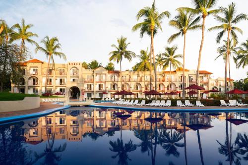 a resort with palm trees and a swimming pool at Grand Decameron Complex Bucerias, A Trademark All-Inclusive Resort in Bucerías