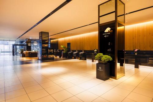 a lobby with a potted plant in a building at Hotel Gracery Shinjuku in Tokyo
