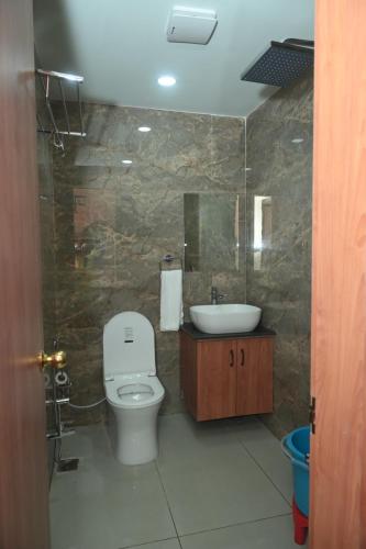 a bathroom with a white toilet and a sink at Hotel Elite Suites in Padrauna