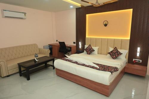 a bedroom with a bed and a couch and a table at Hotel Elite Suites in Padrauna