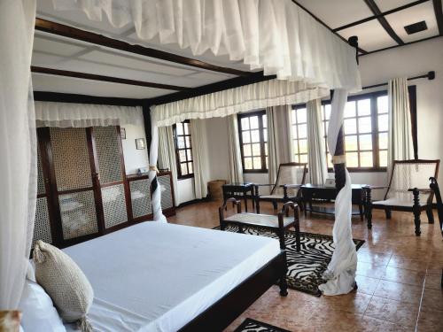 a bedroom with a bed and a table and chairs at Kilulu Luxury Island, Watamu in Watamu