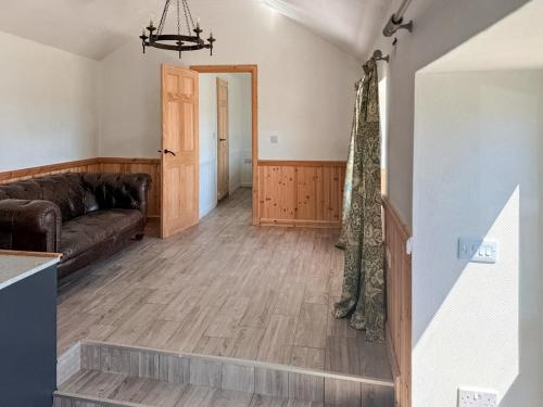 a living room with a couch and a wooden floor at Post Office Lodge in Manish