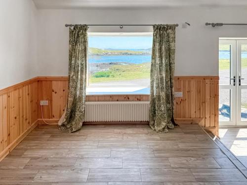 a room with a large window with a view at Post Office Lodge in Manish