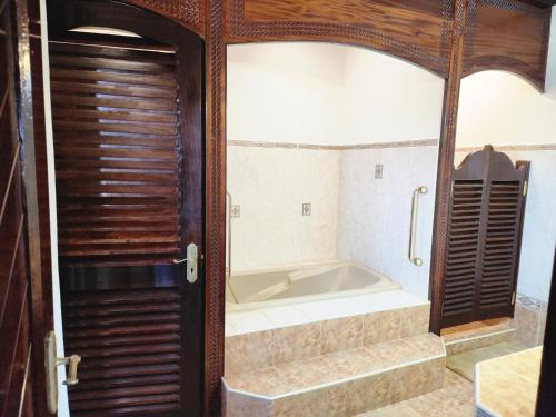 a bath tub sitting inside of a bathroom at Kilulu Luxury Island, Watamu in Watamu