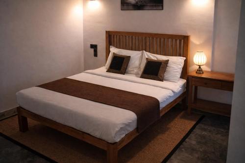 a bedroom with a large bed with two pillows at Golf Resort Par 3 in Digana