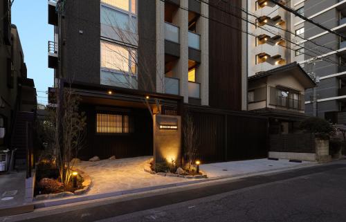 a building with lights on the sidewalk in a city at GRACE STAY Hiroshima Peace Memorial Park in Hiroshima