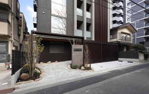 a building with a fence and some plants on a street at GRACE STAY Hiroshima Peace Memorial Park in Hiroshima