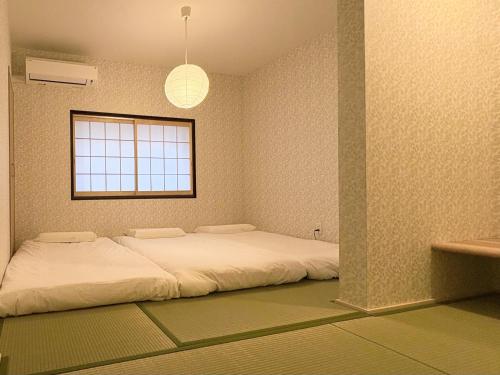 a bedroom with a large white bed in it at 和居 琉璃 和を感じるレイアウトで心も体も休まる宿 in Wada