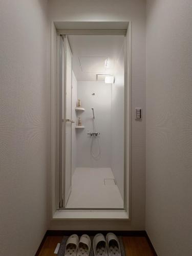 a bathroom with a shower with a glass door at 和居 琉璃 和を感じるレイアウトで心も体も休まる宿 in Wada
