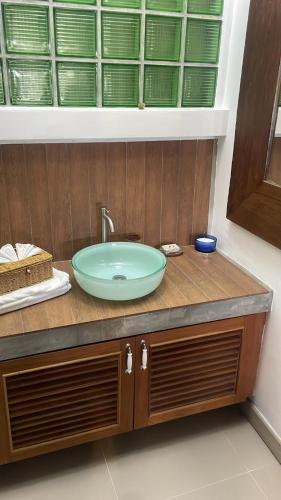 a bathroom sink with a green bowl on a counter at The Lighthouse Seaview Hotel in Rawai Beach