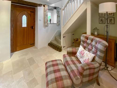 a living room with a couch and a chair at Folly Cottage in Avening