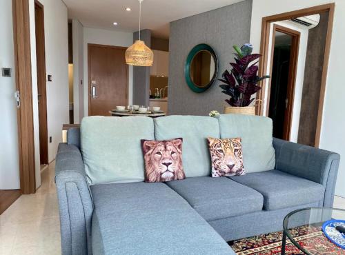 a blue couch in a living room with two lion pillows at Stella Maison KLCC in Kuala Lumpur