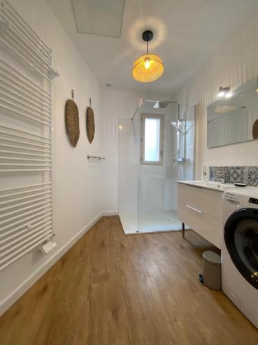 a white kitchen with a sink and a washing machine at Le Cocon de Langes in Orange