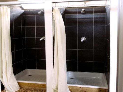 a bathroom with a shower with a tub and a shower curtain at Matatane Camp - Babanango Game Reserve in Babanango