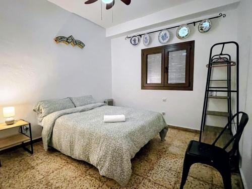 a bedroom with a bed and a ladder and plates on the wall at casa rural Ribera del Hueznar in Constantina