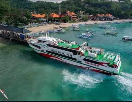 a boat in the water next to a beach at GiliTicket fast ferries in Padangbai