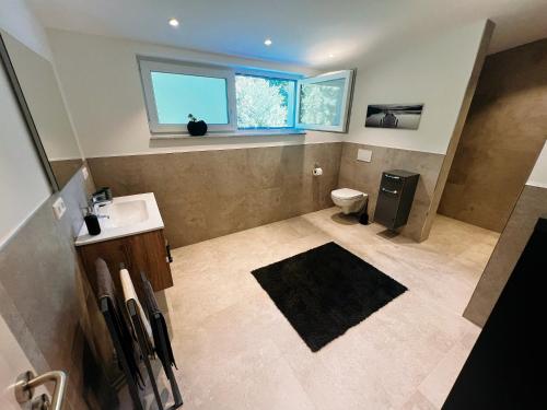a bathroom with a sink and a toilet and a window at Ferienhaus DONAUzeit in Sigmaringen