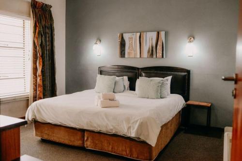 a bedroom with a bed with white sheets and pillows at La Rona Hospitality Services in Rustenburg