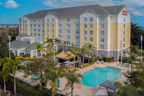 an image of a hotel with a pool and palm trees at Hilton Garden Inn Orlando International Drive North in Orlando