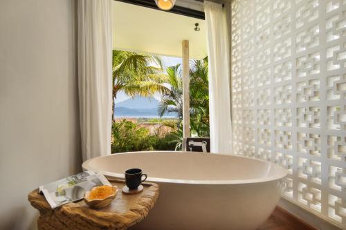a bath tub in a room with a window at Villa Utopia in Nusa Lembongan