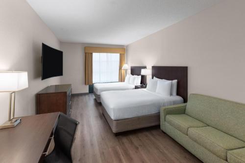 a hotel room with a bed and a couch at Wingate by Wyndham Destin in Destin
