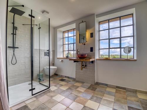 a bathroom with a glass shower and a toilet at Country Lodge - Stall in Tating
