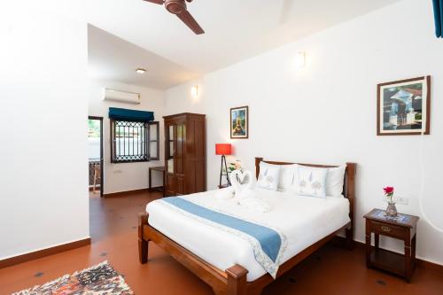 a bedroom with a large bed with white sheets at Quinta da Praia by Semper Felix in Calangute