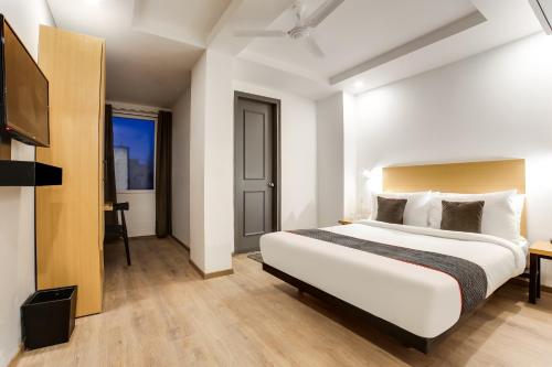 a hotel room with a bed and a television at Townhouse Derawal Nagar in New Delhi
